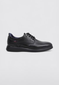 Zapatos de cuero negros con un acabado suave, puntera redonda y detalles de cordones. Presentan una suela negra delgada y un interior púrpura en contraste.
