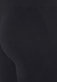 Zwarte leggings gemaakt van rekbare, gestructureerde stof met een hoge tailleband en een gladde afwerking, ontworpen voor een comfortabele pasvorm en beweging.