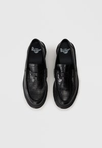 Čierne kožené slip-on topánky s textúrovaným vzorom pripomínajúcim krokodíliu kožu. Obsahujú kontrastné švy a hrubú gumovú podrážku.