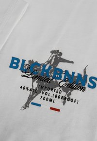 Wit textiel met blauwe en grijze bedrukte tekst. Bevat een afbeelding van een ruiter, met "LIMITED EDITION" en details over het alcoholgehalte onderaan.