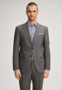 Gray tailored suit with notched lapels, two buttons, and side pockets. Underneath, a light blue polka dot shirt with a button-down collar.