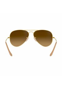 Occhiali da sole aviator dorati con lenti graduali marroni e accenti beige sulle tempie. Presentano cuscinetti nasali regolabili per una vestibilità sicura.