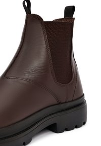 Bruine Chelsea-boot van glad leder met gestructureerde elastische panelen, voorzien van een robuuste rubberen zool en een trekstop voor eenvoudige instap.