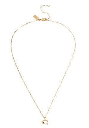 Collier délicat en chaîne d'or avec un petit pendentif en forme de fer à cheval et un fermoir ajustable muni d'une étiquette.