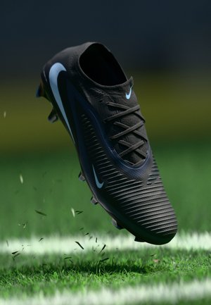 Black athletic shoe with textured upper, dynamic design, and light blue accents. Features a lace-up closure and studs suitable for grass surfaces.