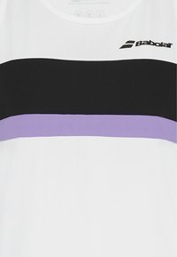 Top sportivo bianco senza maniche con strisce orizzontali nere e viola e logo Babolat sul petto.