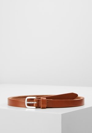 Ceinture en cuir marron avec boucle en métal argenté reposant à plat sur une surface blanche sur fond gris clair uni.