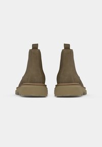 Brune ruskinds ankelstøvler med en glat overflade, elastiske sidepaneler og en tykk gummisål for godt greb. Har en bageste pull-tab.
