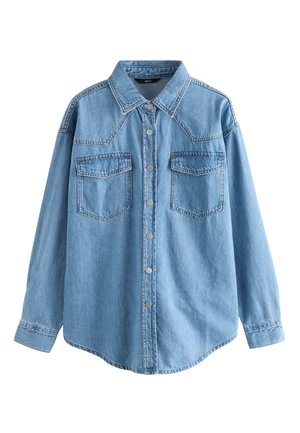 Camisa de mezclilla azul claro con cuello puntiagudo, mangas largas, dos bolsillos en el pecho, botones plateados y dobladillo ligeramente curvado.