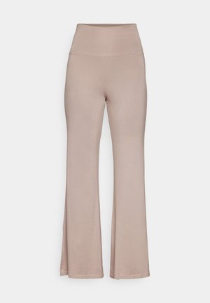 Kõrge vöökohaga, heledast beežist flared püksid, mis on valmistatud pehmest kangast, millel on sile tekstuur ja ei ole nähtavaid mustreid ega metallosi.