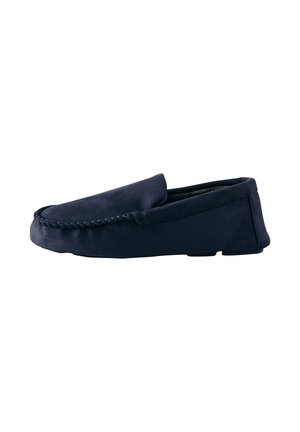 Mocasini slip-on din piele întoarsă albastru închis, cu detalii cusute de-a lungul vârfului și talpă plată, văzuți din profil pe fundal alb.