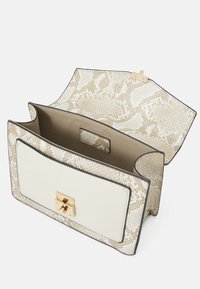 Crème en slangenpatroon handtas met een gouden sluiting, met een gestructureerd ontwerp en een gladde binnenvoering. Geopend om de binnenkant te tonen.