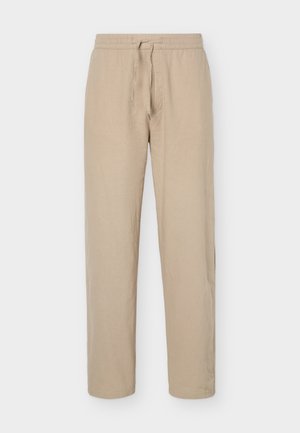 Pantalon beige à taille élastique avec cordon de serrage, jambes droites et poches latérales, présenté sur un fond blanc uni.