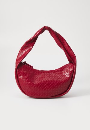 Punainen kudottu nahkakäsilaukku, jossa on kaareva, pehmustettu kahva, vetoketjukiinnitys ja teksturoitu pinta, joka heijastaa kiiltävää hohtoa.