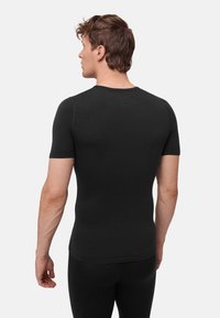 Mustan värinen lyhythihainen istuva paita, jossa sileä pinta ja pyöreä pääntie, näkymä takaa. Materiaali näyttää joustavalta ja hengittävältä.