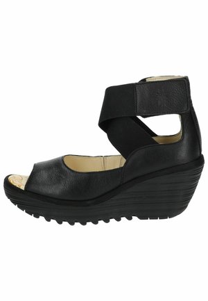 Black wedge sandal featuring a peep toe design, curved sole, and elastic strap across the ankle. Textured leather upper with light interior.