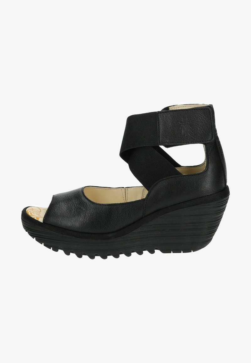 Černé wedge sandály s designem peep toe, zakřivenou podrážkou a elastickým páskem přes kotník. Texturovaný kožený svršek s lehkým interiérem.