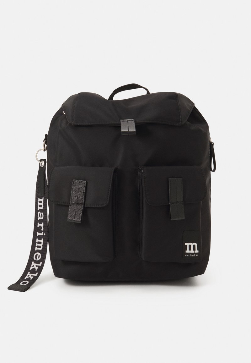 Zaino in tessuto nero con pattina pieghevole, due tasche frontali, una toppa con logo e una tracolla con motivo. Presenta un manico superiore e cerniere.