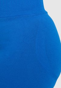 Blauwe leggings met een geribbelde tailleband en een gestructureerde stof met een gladde afwerking, ontworpen voor comfort en flexibiliteit.