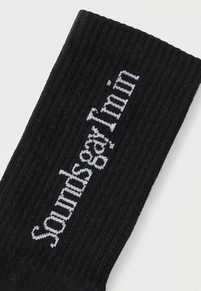 Μαύρες ριγέ κάλτσες με λευκό κείμενο «sounds gay I'm in» στη μία πλευρά, κατασκευασμένες από μείγμα βαμβακιού με απαλή υφή.