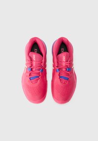 Baskets de sport roses vives avec un design en maille, des lacets bleus et des accents blancs. Présente une surface texturée et une forme de bout arrondi.