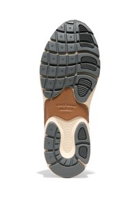 Suola della scarpa realizzata con una combinazione di gomma grigia e pelle beige, con motivi di battistrada texturizzati per una migliore aderenza e supporto.