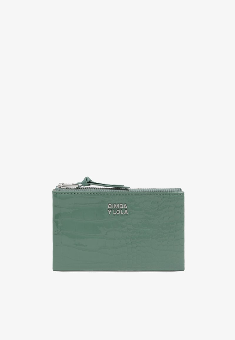 Zaļš patentēts ādas maks ar krokodila tekstūru, ar rāvējslēdzēja aizdari un sudraba logo detaļu priekšpusē. Taisnstūra forma.