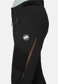 Zwarte outdoorbroeken met een slank ontwerp, ritszakken en een logo. Gemaakt van duurzaam, gestructureerd materiaal met accentpanelen.