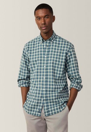 Camisa de botones con un patrón de cuadros en azul y verde, material de algodón, mangas largas arremangadas en los puños y diseño de cuello recto.