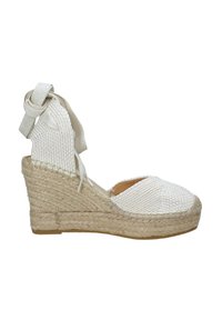 Espadrillas a zeppa bianche con tomaia in tela intrecciata, suola in corda di juta e lacci in tessuto per la caviglia, caratterizzate da una punta rotonda e un design testurizzato.