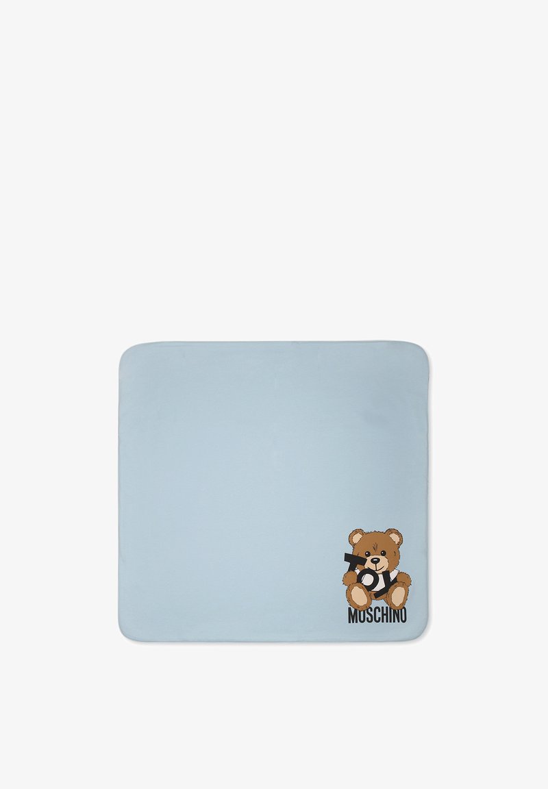 Coperta azzurra chiaro con un orso dei cartoni animati che tiene una pistola giocattolo. Include il testo "MOSCHINO" e un dettagliato design dell'orso con accenti di pelliccia marrone.