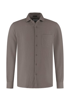 Dlouhý rukáv pruhovaná košile v barvě kapučínové s texturovanou látkou, zapínáním na knoflíky vpředu, špičatým límečkem a náprsní kapsou na levé straně.