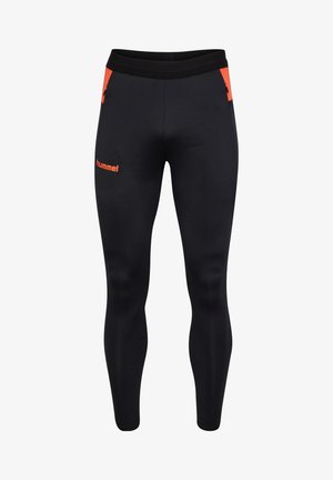 Zwarte sportlegging met een gladde textuur, voorzien van een oranje accent op de zak en een logo op het bovenbeen. Elastiche tailleband.