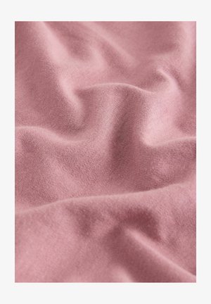 Puha rózsaszín anyag finom kötött textúrával és lágy redőkkel, amelyek finom árnyékokat és kiemeléseket hoznak létre a felületen.