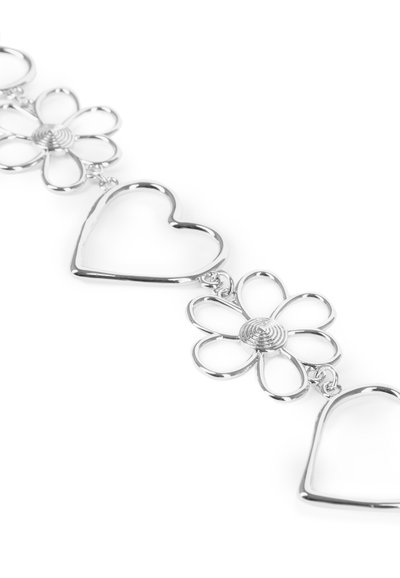 Sølvarmbånd med skiftende blomster- og hjerteformer, med åbne former og glatte overflader, der reflekterer lyset.