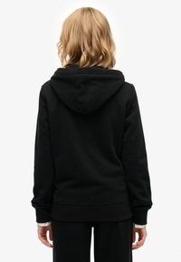 Felpa nera con cappuccio realizzata in un morbido misto cotone, caratterizzata da un grande cappuccio, polsini a coste e una vestibilità comoda. Tessuto liscio con dettagli minimi.