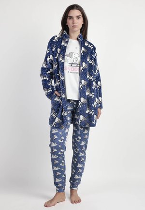 Conjunto de pijama de felpa azul con patrones de Snoopy y Woodstock; incluye pantalones largos y una chaqueta con cuello y bolsillos. Camiseta gráfica blanca debajo.