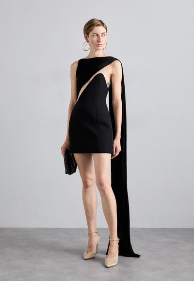 Juodas mini suknelė su asimetriškai kirpta ir drapiruota medžiaga ant vieno peties. Lygus tekstūra, derinama su metalinėmis detalėmis akcentuotais aukštakulniais ir rankine.