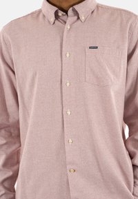 Geruite overhemdbloem in rood en wit, gemaakt van katoen. Heeft een borstzak en knopen met een subtiele glans.