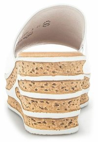 Sandales blanches à talon compensé avec une semelle en liège stratifiée au motif texturé, finition lisse et design à dos ouvert.