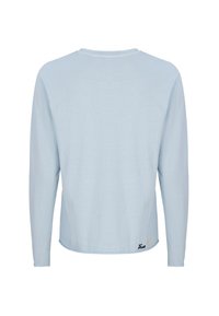 Hellblaues Langarmshirt mit rundem Ausschnitt und lockerem Schnitt. Mit dezenten Nähten und einem kleinen gestickten Detail am Saum.