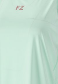 Ljusgrön atletisk skjorta i mjukt tyg, med en subtil lyster och en liten "FZ"-logotyp i rosa fram på.