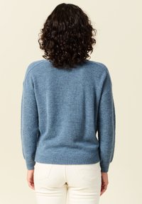 Maglione blu a maglia con una vestibilità rilassata, caratterizzato da maniche lunghe, polsini e orlo a coste, e un motivo testurizzato sui lati.