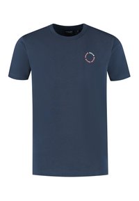 Navyblauwe katoenen t-shirt met een ronde hals. Heeft een klein rond logo op de borst in lichtroze met witte tekst. Korte mouwen.