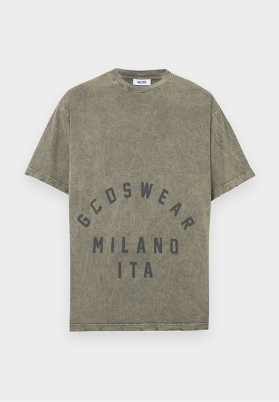 Tricou din bumbac de culoare verde măsliniu, cu guler rotund, mâneci scurte și imprimeu frontal care spune "GCDSWEAR MILANO ITA" cu litere negre îngroșate.