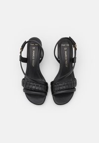 Mustat korkokengät, joissa on kudottu remmimalli, sileä pinta, säädettävä ankle-nauha ja minimalistinen siluetti. Koko 37.