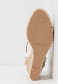 Semelle d'une sandale compensée beige avec fond en caoutchouc texturé, nom de la marque "Refresh", taille 37, et brides latérales en tissu tissé visibles.