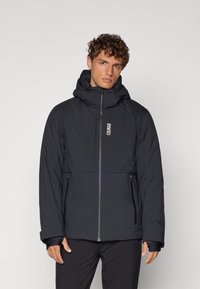 Schwarze gepolsterte Jacke mit hohem Kragen und verstellbarem Kapuze, ausgestattet mit einem Frontreißverschluss und zwei seitlichen Taschen. Glattes Material mit dezentem Branding.
