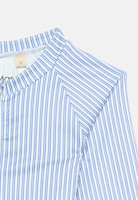 Modra in bela srajca z navpičnimi črtami, okrogel izrez in vidna oznaka velikosti "M" na belem ozadju.