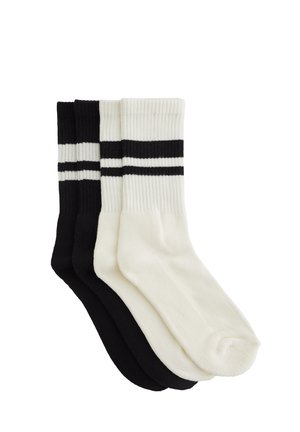 Drei Paar Socken: ein schwarzes, ein weißes und eines mit schwarz-weißen Streifen. Gerippte Textur und Knöchelhöhe. Weicher Baumwollmix.